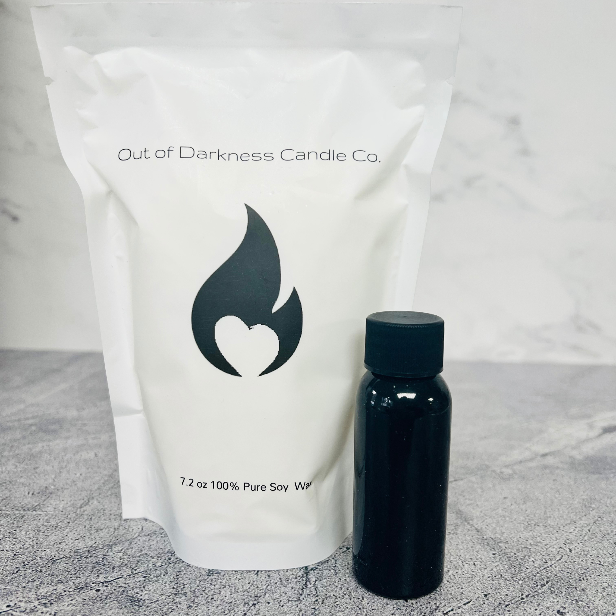 White Bag with black flame logo says 7.2 oz 100% pure soy wax black bottle next to it