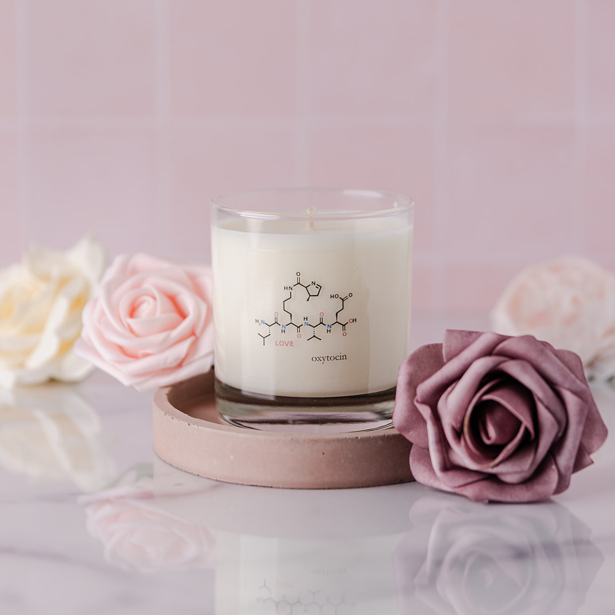 Clear Glass Jar Candle labeled with the molecule of love- oxytocin surrounded by pink roses